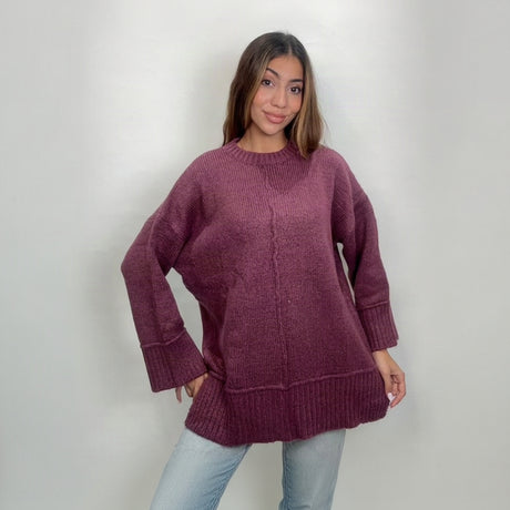 Berry magenta relaxed wool sweater with side slits, worn with light jeans