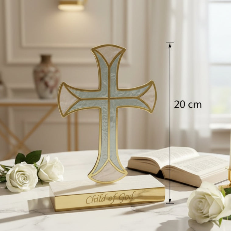 Pale blue pearlised cross on a marble table beside an open book and white roses