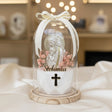 Pearlised Madonna bust above a black and gold cross among dusty pink dried stems