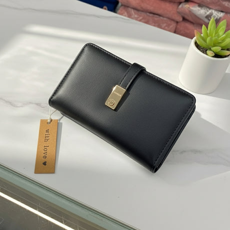 Black matte wallet on a white counter with a plant in the background