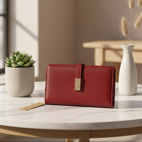 Red wallet on a marble surface with a plant and vase in the background