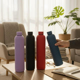 Matte 1L water flasks grouped on a living room coffee table