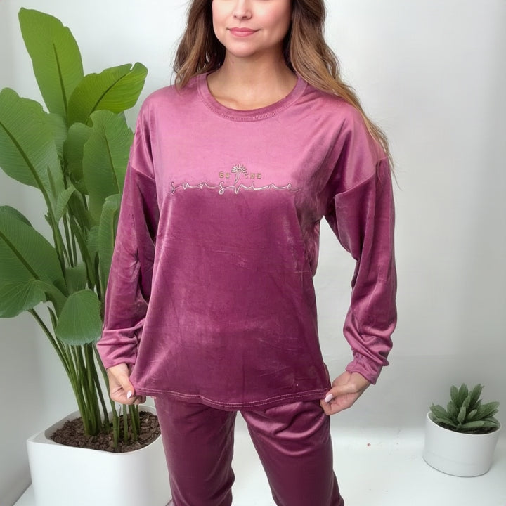 Close up of a mauve pink velvet sweatshirt style pajama top with metallic script print