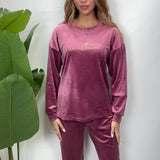 Woman in a mauve pink velvet PJ set with a Be The Sunshine print top and matching pants