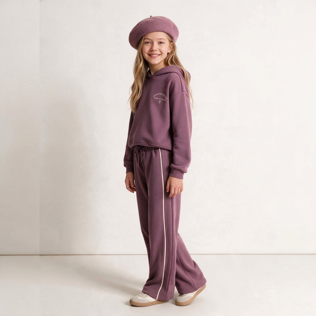 Girl in a mauve hoodie set and matching beret posing with hands in pockets