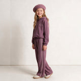 Girl in a mauve hoodie set and matching beret posing with hands in pockets