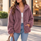 Woman wearing an open mauve teddy fleece zip jacket with a hand in the side pocket