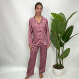 Woman in a mauve velvet button up PJ set with a collared long sleeve shirt and matching pants