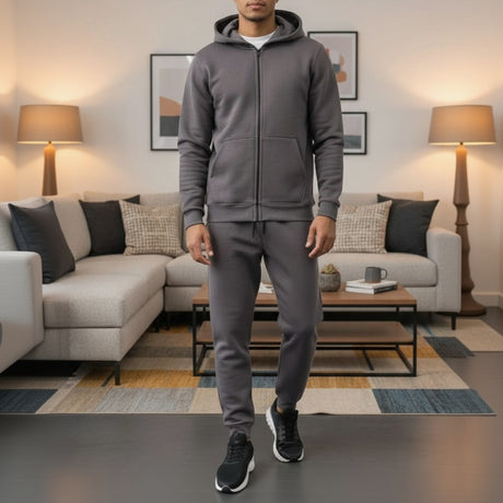 Man wearing a grey tracksuit in a living room setting