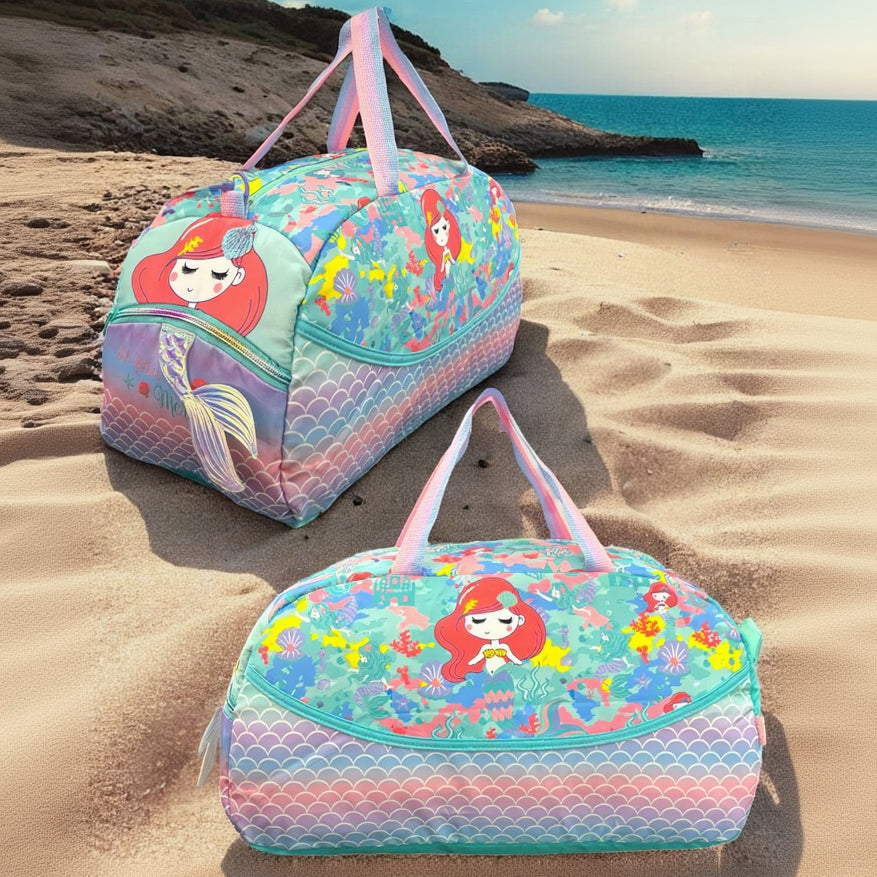 Two pastel mermaid duffle bags on sand, one showing the front print, the other the end pocket