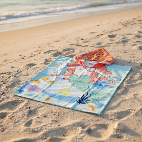 Colorful towel with cartoon design on a sandy beach