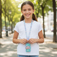 Smiling girl wearing a mint green mermaid card wallet on a pastel printed neck lanyard