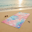 Colorful beach towel on a sandy beach with ocean waves in the background