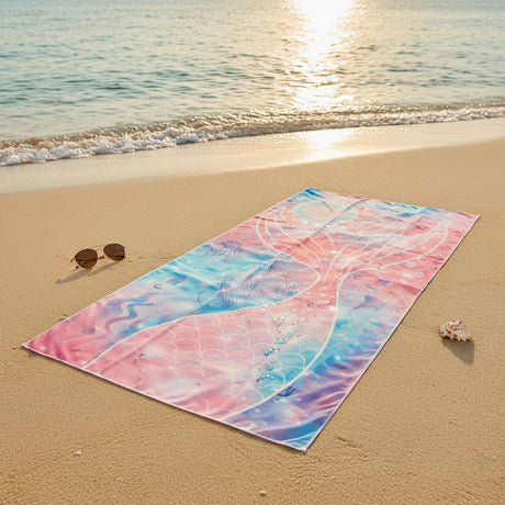 Colorful beach towel on a sandy beach with ocean waves in the background