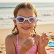 Young girl wearing colorful goggles on a beach