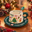 White Christmas teacup with gingerbread and tree prints on a dark green Merry Christmas saucer