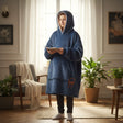 Child in a navy hooded blanket with a sherpa lined hood standing in a living room