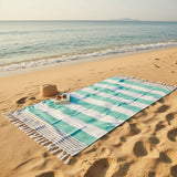 Beach towel with checkered pattern on a sandy beach with ocean view