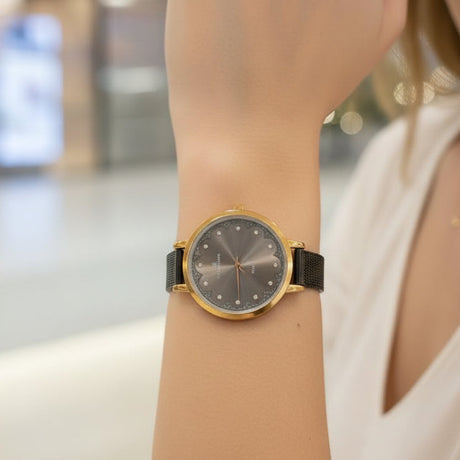 Gold case watch with grey crystal dial and black mesh strap