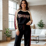 Woman in a black Montaigne sweatshirt with cream raglan sleeves and maroon striped wide leg pants