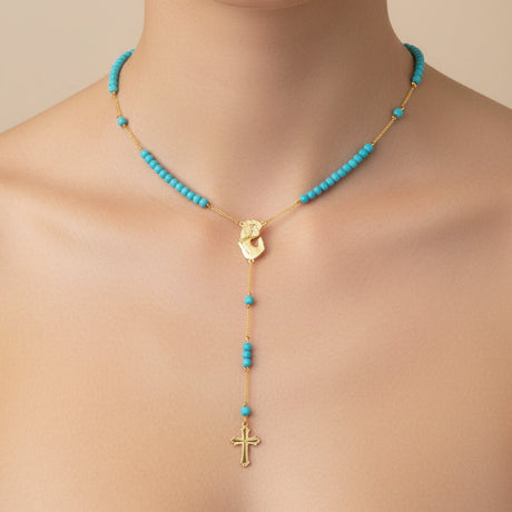 Mother Mary necklace with turquoise beads and gold accents on a neutral background