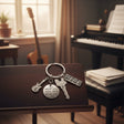 Guitar and keyboard keychain with a Do What You Love disc on a music stand