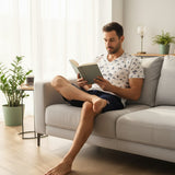 Nautical print pyjama set worn reading a book on a light grey sofa