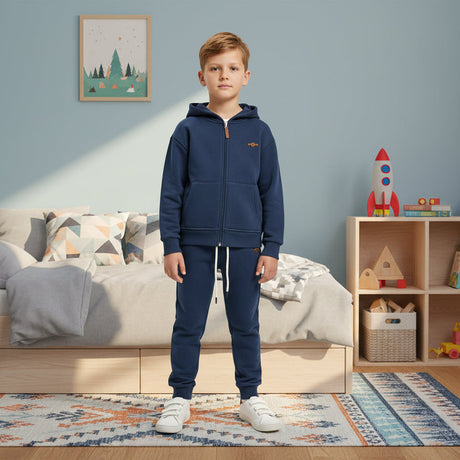 Child in a navy blue zip up hooded jacket with matching navy joggers and a small chest badge