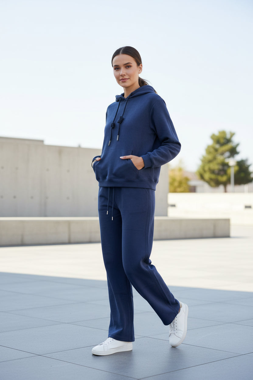Navy hoodie and sweatpants set worn by a person walking outdoors