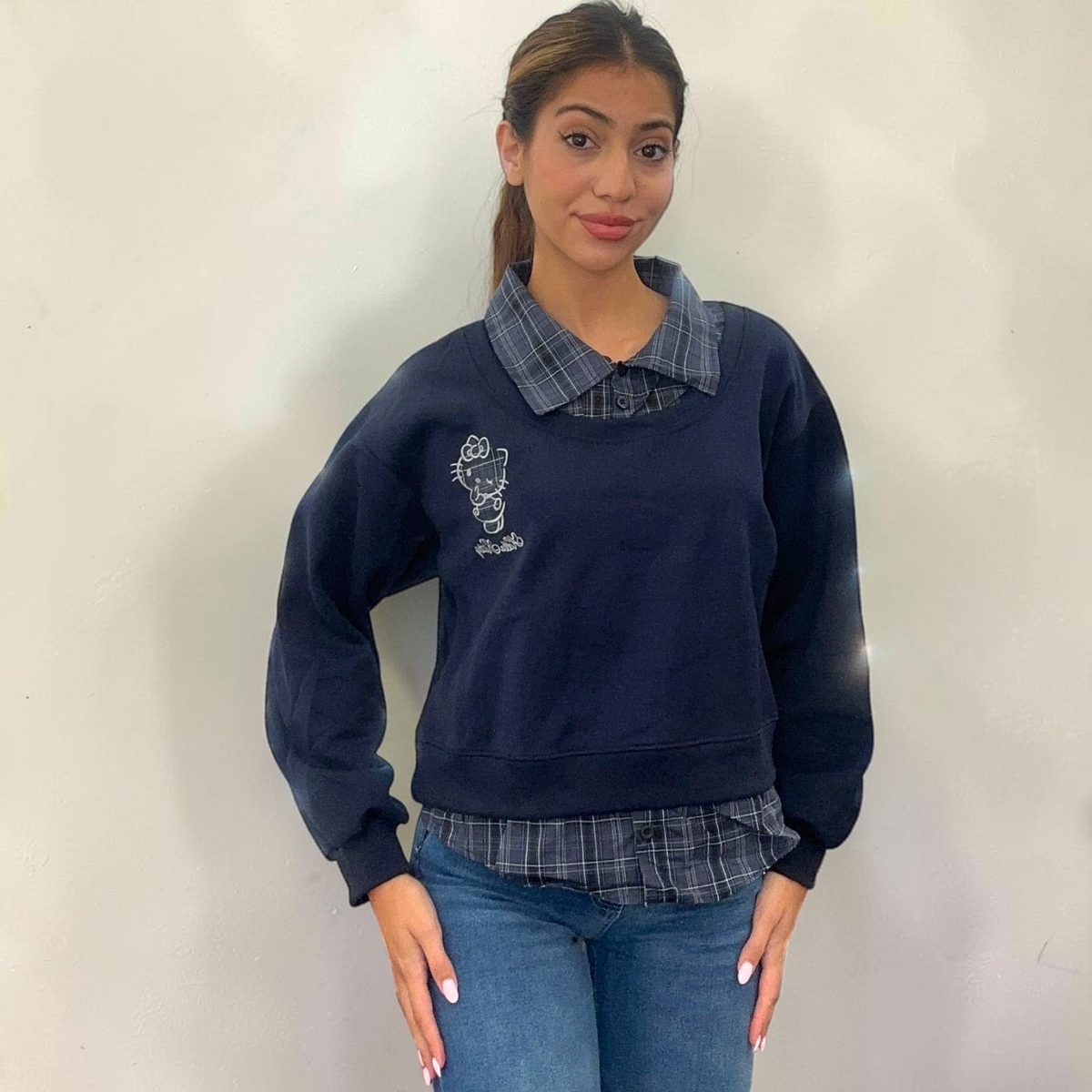 Navy sweatshirt with a check shirt collar and matching check hem, worn with blue jeans