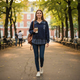 Navy layered sweatshirt worn with jeans on a tree lined path