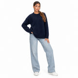 Navy blue wool knit crew neck sweater with light jeans and white sneakers