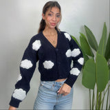Woman in a navy cloud knit cardigan with button front and cropped hem, hand in her pocket