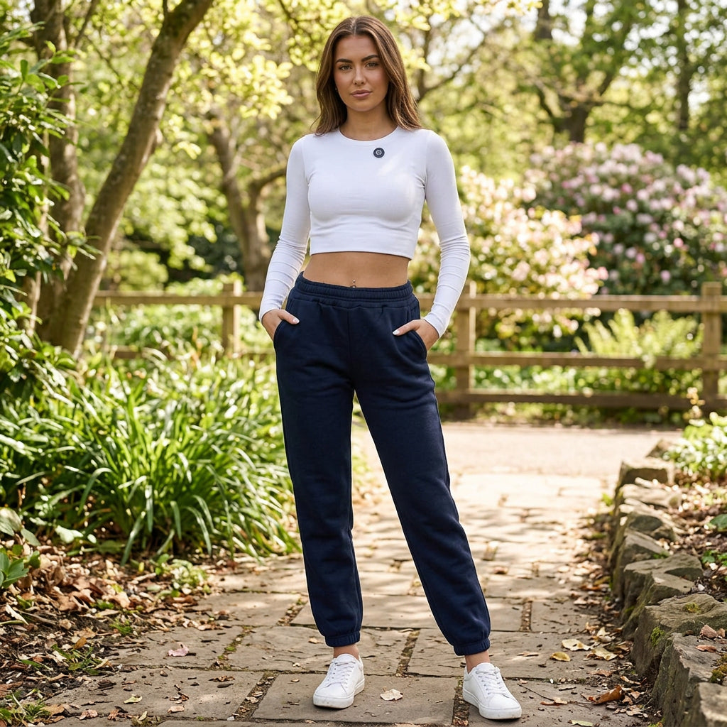 Women's navy blue cuffed sweatpants worn front on with both hands in the side pockets