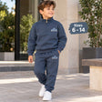 Boy walking in a navy half zip sweatshirt and jogger set with Epic Adventure print and white sneakers