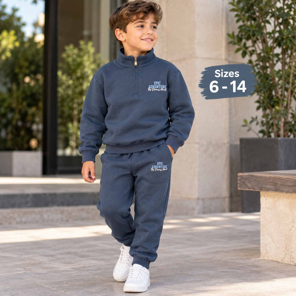 Boy walking in a navy half zip sweatshirt and jogger set with Epic Adventure print and white sneakers