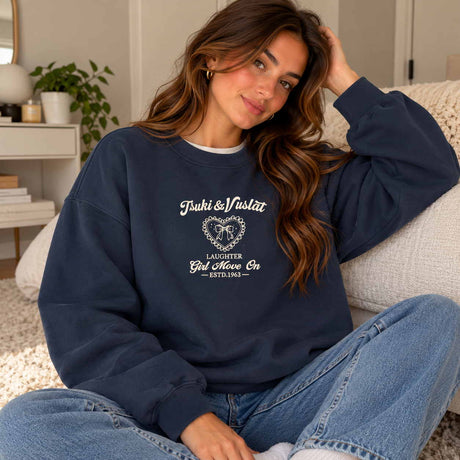 Woman in a navy sweatshirt with a vintage heart crest print on the chest, relaxing with jeans