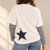 Back of the white tee with a distressed navy star print and navy striped sleeves