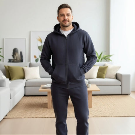 Man wearing a navy tracksuit standing in a modern living room