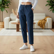 Person wearing navy pants and white sneakers in a living room setting
