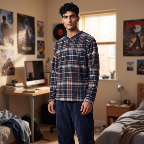 Boy in a navy plaid fleece pyjama top with button placket and plain navy fleece bottoms