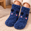 Navy fuzzy kids socks with a smiling bear face, dark navy pom pom ears and pink cheeks