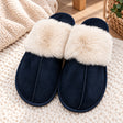 Navy suede look slippers with a fluffy cream fur collar and stitched seam on a knit rug