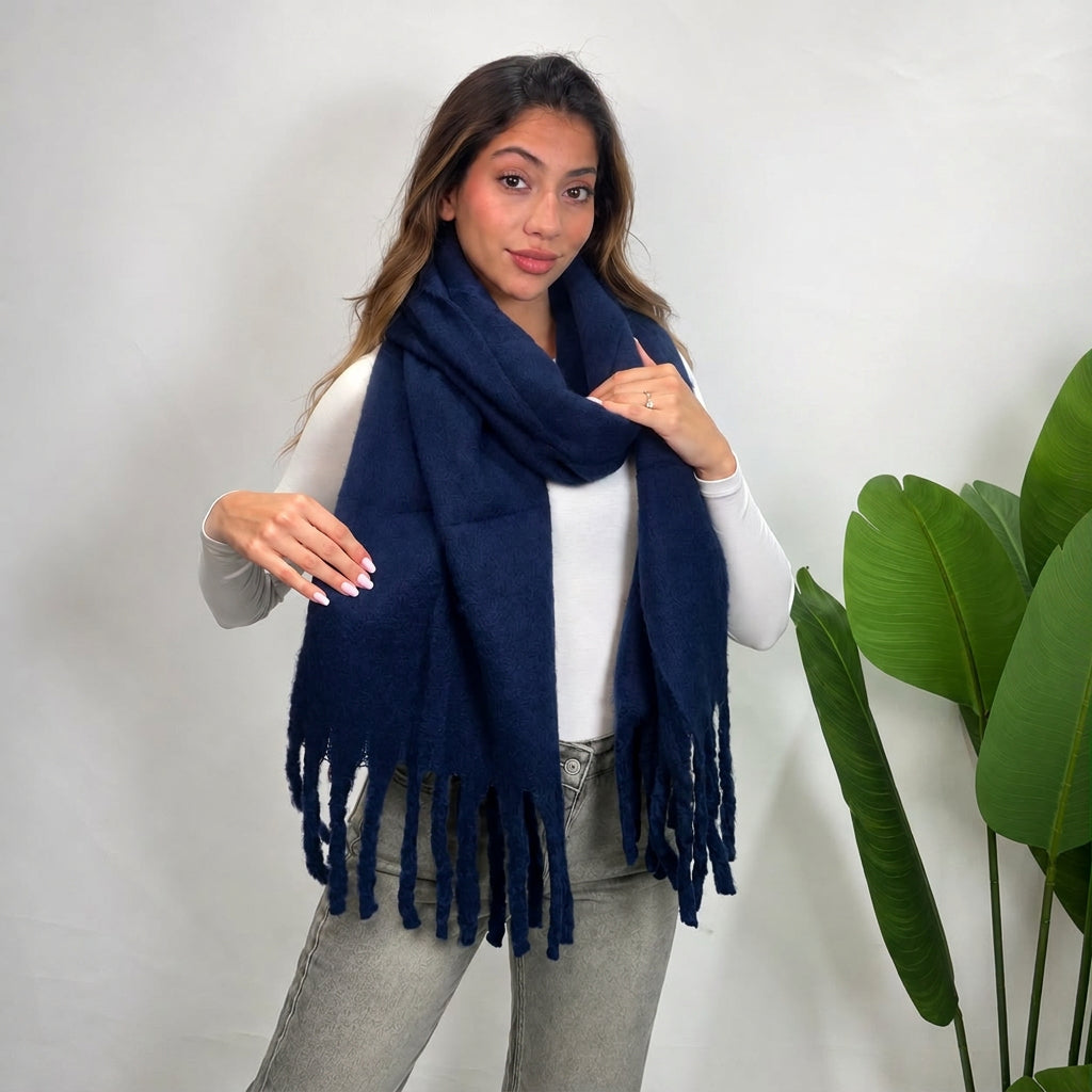 Woman wearing a navy brushed blanket scarf looped around her neck with long twisted tassels
