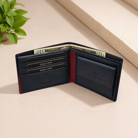 Open navy bifold with red lining at the fold, three card slots and folded dollar notes