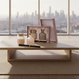The greige set on a pale wood table with a hazy city skyline through the window
