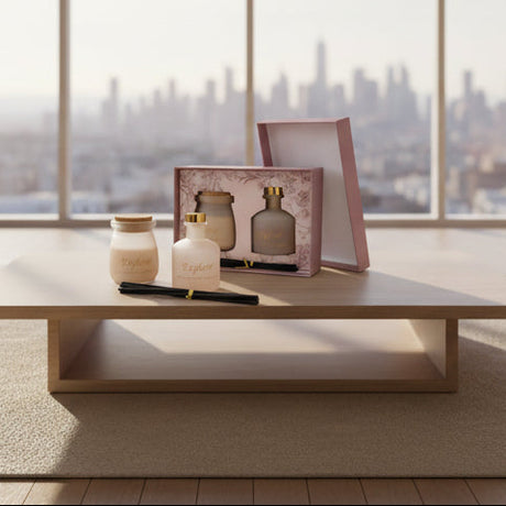 The greige set on a pale wood table with a hazy city skyline through the window