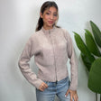 Oatmeal zip up knit cardigan with a funnel neck and ribbed cuffs, worn with light jeans