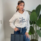 Oatmeal cropped hoodie worn with jeans and a navy tote in a bright room