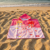 Pink cartoon crab towel on a gray floor with feet in the background